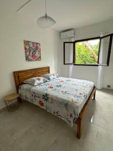 1 dormitorio con 1 cama en una habitación con ventana en Ti Kaz Pitaya, en Saint-Pierre