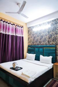 1 dormitorio con 1 cama con cortinas moradas en Roomshala 126 Mannat Inn Laxmi Nagar, en Nueva Delhi