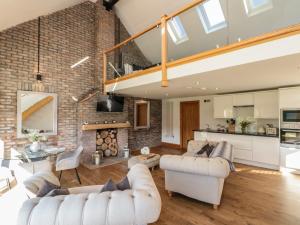 a living room with white furniture and a brick wall at Kaitkyella Lodge in Scarborough