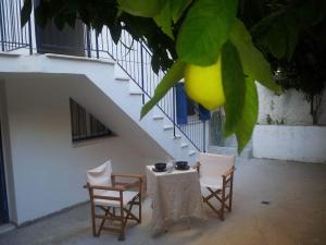 a table and chairs with a lemon hanging from a tree at Spacious Family Garden Apartment in Loutraki