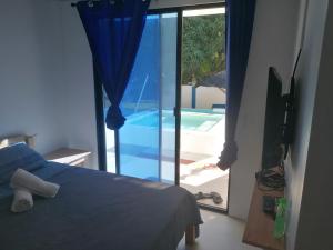 a bedroom with a bed and a view of a swimming pool at Villa Jana, Bantayan, Santa Fe in Bantayan Island