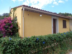 a yellow house with a hedge in front of it at Villa Petra in Sainte-Maxime