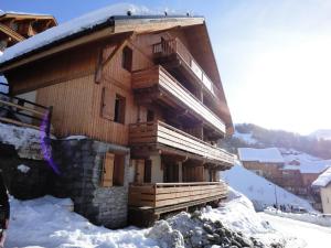 a large wooden building with snow on the ground at Ancolie Chalets De La Vallee D'or - 3 Pièces pour 6 Personnes 84 in Valloire