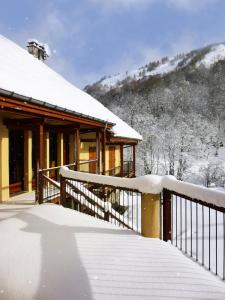 a house covered in snow in front of a building at Résidence Les Fermes Du Planet - Chalets pour 12 Personnes 74 in Valloire