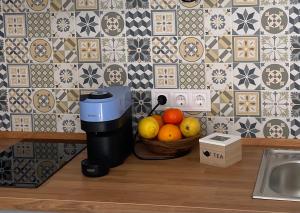 a coffee maker sitting next to a bowl of fruit at Pisito de la Lola Flores in Santiponce