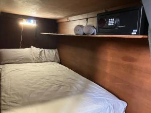 ein kleines Schlafzimmer mit einem Bett und einer Mikrowelle in der Unterkunft C and C Backpack in Stawell