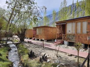 a group of buildings with trees and a creek at Wooden Nest Cottage Hunder, Nubra Valley in Nubra