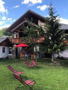 a group of chairs sitting in the grass in front of a house at Chalet Colenfrey - Chalets pour 10 Personnes 14 in Valloire