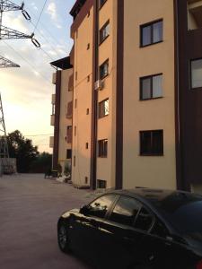 une voiture noire garée devant un bâtiment dans l'établissement Eclipsei ApartHotel, à Popeşti-Leordeni