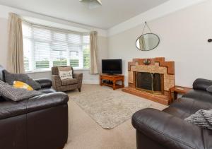 a living room with two couches and a fireplace at Dolwar in Abersoch
