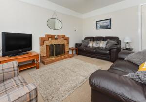 a living room with a couch and a fireplace at Dolwar in Abersoch