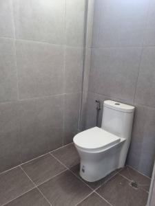 a bathroom with a white toilet in a tiled room at Rest at Thachang Hotel in Ban Hua Han