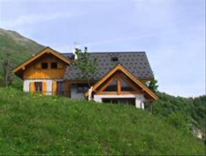 a house sitting on top of a grassy hill at Chalet Les Aiguilles - Pièces 34 in Valloire