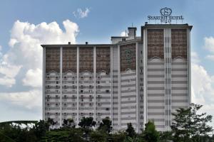 a hotel building with a clock on top of it at Lorin Syariah Solo Hotel in Solo