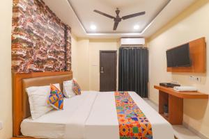 pokój hotelowy z łóżkiem i telewizorem w obiekcie FabHotel Swarn Banquet w mieście Kakarmatha