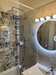 a bathroom with a shower and a sink and a mirror at Ambassadeur Hotel - Cherbourg Port de Plaisance in Cherbourg en Cotentin