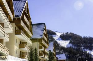 a view of a building with a snowy mountain at Les Chalets Valoria - 3 Pièces pour 6 Personnes 24 in Valloire