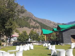 a row of white chairs in front of a building at Smile Resort , Himachal Pradesh in Shamshi