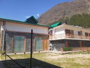 a house with a mountain in the background at Smile Resort , Himachal Pradesh in Shamshi