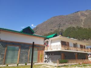 a house with a mountain in the background at Smile Resort , Himachal Pradesh in Shamshi