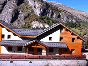 Cabaña de madera con una montaña en el fondo en Les Chalets D'adrien - 4 Pièces pour 8 Personnes 44, en Valloire