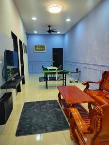 a living room with a ping pong table and a tv at Doleena's Homestay in Sitiawan