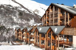 um alojamento de turismo selvagem na neve com montanhas cobertas de neve em Résidence Le Hameau De Valloire - Studio pour 2 Personnes 94 em Valloire