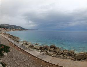 a beach with rocks and the ocean on a cloudy day at House next to the sea side in Derveni