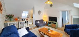 Appartement Ty Cosy في كويبيرون: غرفة معيشة مع أريكة زرقاء وطاولة