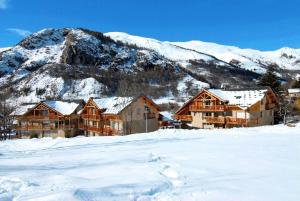 a lodge in the snow in front of a mountain at Résidence La Claree - 4 Pièces pour 8 Personnes 14 in Valloire