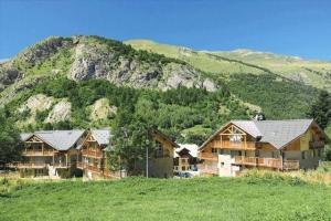 a large wooden house with a mountain in the background at Résidence La Claree - 4 Pièces pour 8 Personnes 14 in Valloire