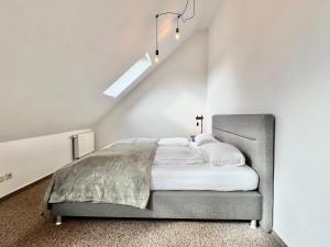 a bedroom with a bed in a white room at Modernes Apartment mit Blick zur Elbe in Klipphausen