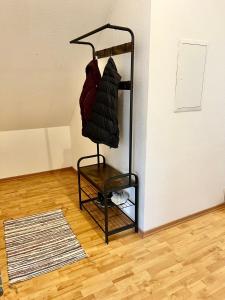 a black rack with coats on it next to a wall at Modernes Apartment mit Blick zur Elbe in Klipphausen +2 photos
