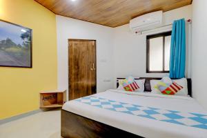 1 dormitorio con 1 cama grande y cortinas azules en OYO A J Mountain View Cottage, en Lonavala