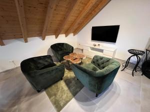 uma sala de estar com duas cadeiras, uma mesa e uma televisão em furnished & equipped TDY-TLA-TLF House-A - vollständig ausgestattetes Ferienhaus em Bruchmühlbach-Miesau