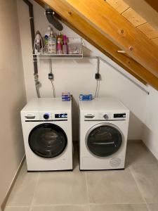 duas máquinas de lavar roupa sentadas uma ao lado da outra numa lavandaria em furnished & equipped TDY-TLA-TLF House-A - vollständig ausgestattetes Ferienhaus em Bruchmühlbach-Miesau