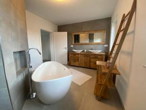 uma casa de banho com uma banheira grande e 2 lavatórios em furnished & equipped TDY-TLA-TLF House-A - vollständig ausgestattetes Ferienhaus em Bruchmühlbach-Miesau