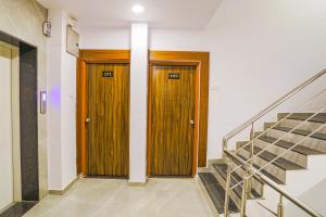 duas portas de madeira num corredor com escadas em FabHotel Royal Stay em Nagpur