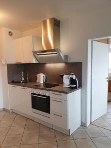 Una cocina con gabinetes blancos y un horno de estufa. en Ferienwohnung Sonnenschein mit Pool und Sauna, en Lahnstein 37 fotos más