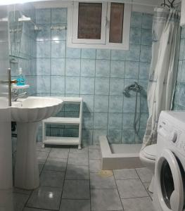 a bathroom with a sink and a shower and a toilet at House next to the sea side in Derveni