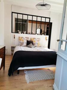 1 dormitorio con 1 cama grande y espejo grande en La Dolce Vita Justine en Vals-les-Bains