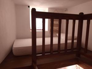 ein kleines Bett in einem Zimmer mit Fenster in der Unterkunft Bella Vista Montagna in Apérathos