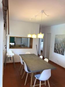 een eetkamer met een tafel en witte stoelen bij La Villa Lisboa: Maison de vacances in Aroeira