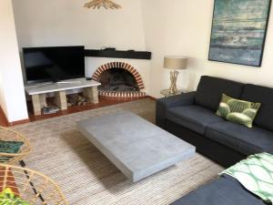 een woonkamer met een bank en een open haard bij La Villa Lisboa: Maison de vacances in Aroeira