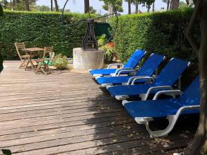 een rij blauwe ligstoelen op een houten terras bij La Villa Lisboa: Maison de vacances in Aroeira