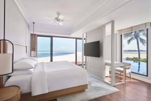 una camera con letto bianco e vista sull'oceano di Renaissance Hoi An Resort & Spa a Hoi An