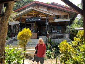 a woman standing in front of a building at Olala Bungalows and Restaurant in Sabong