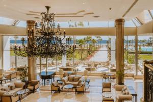 a large lobby with a chandelier and tables and chairs at Baron Resort Sharm El Sheikh in Sharm El Sheikh