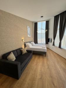 een woonkamer met een bank en een bed bij Triangle Rooms in Raška