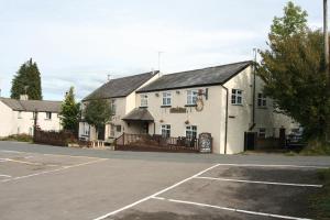 um edifício com um parque de estacionamento em frente em Busmans Holiday Anyone em Pontypool